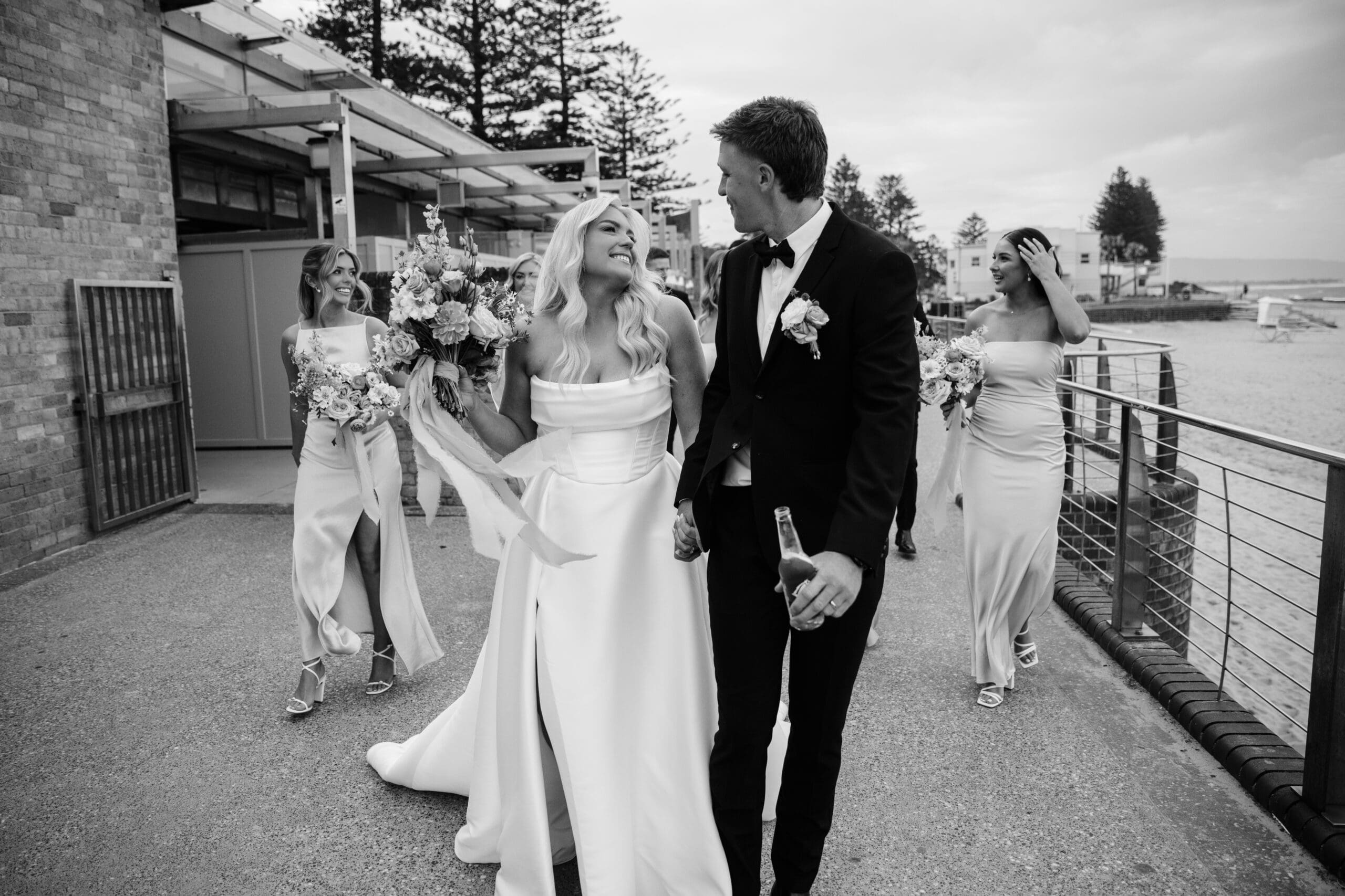 Bride and groom walking with their bridal party during wedding portraits.